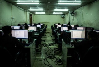 Call centre workstations in dim fluorescent light, Myanmar-Thailand border region