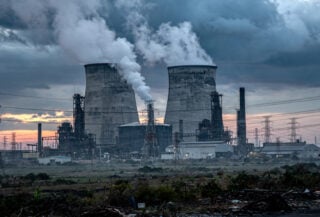 Coal power plant with cooling towers in Johor, Malaysia, industrial landscape at dusk
