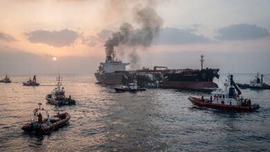Damaged tanker in Strait of Hormuz with rescue vessels responding