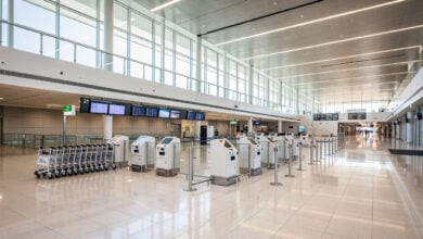 Modern airport arrivals hall with digital kiosks and signage, contemporary design