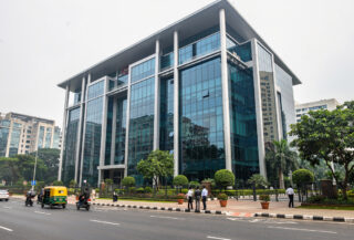 Modern tech office building in Bengaluru with street traffic and pedestrians