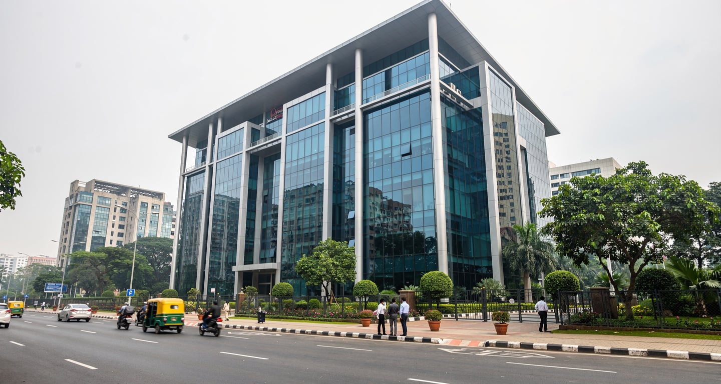 Modern tech office building in Bengaluru with street traffic and pedestrians