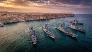Naval vessels transiting the Strait of Hormuz near Iranian coast