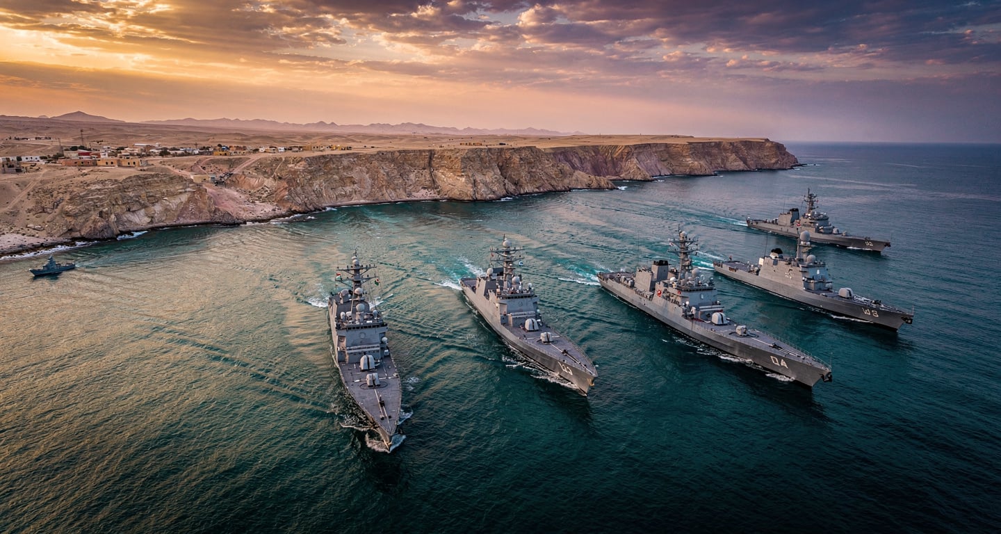 Naval vessels transiting the Strait of Hormuz near Iranian coast