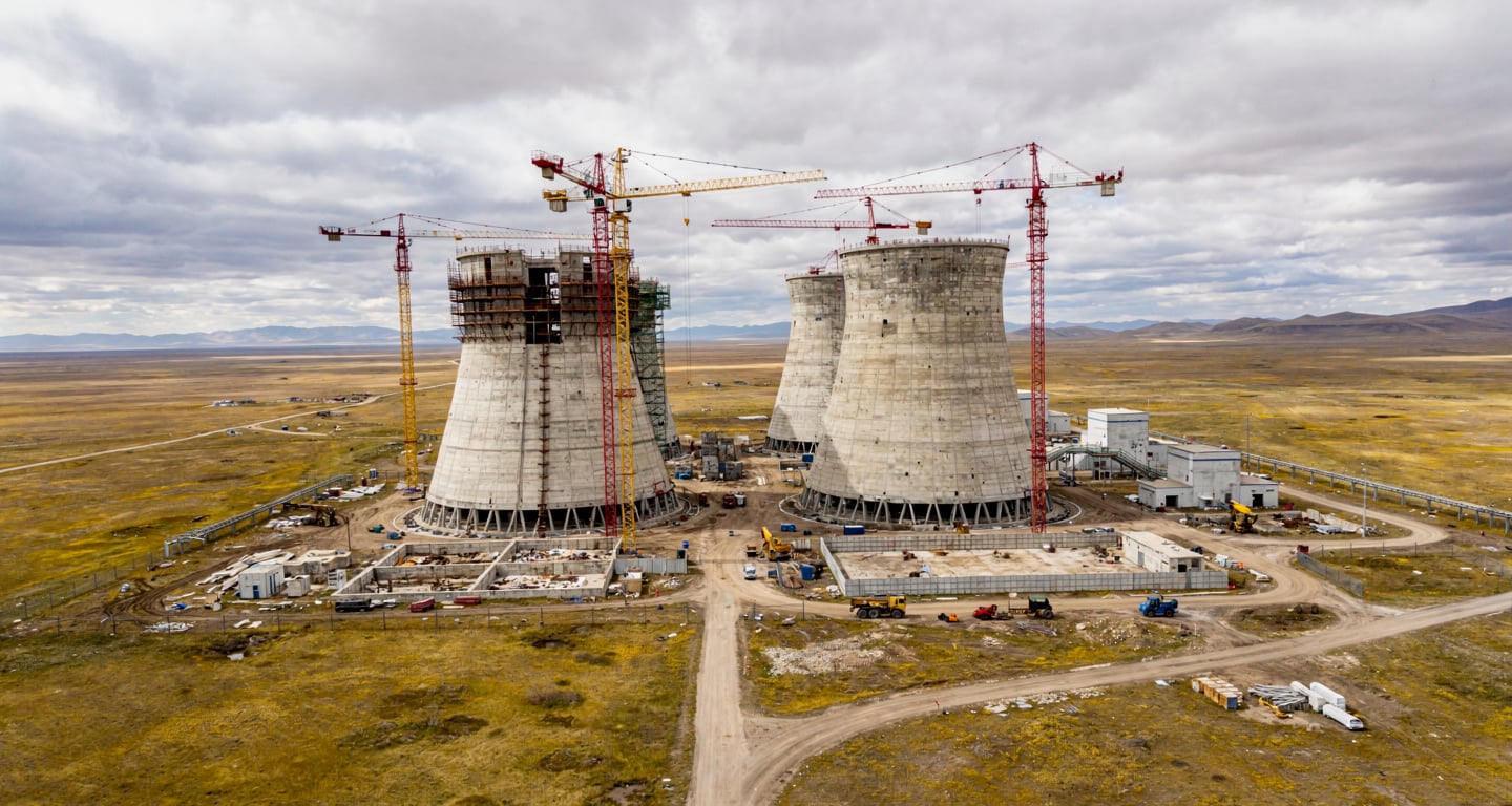 Nuclear power plant construction site with cooling towers in Central Asian steppe landscape