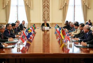 Pacific Island leaders at regional summit meeting, formal diplomatic setting with national flags
