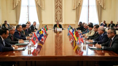 Pacific Island leaders at regional summit meeting, formal diplomatic setting with national flags