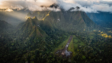 Papua highlands airstrip surrounded by dense jungle and mountains at dawn