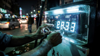 Petrol pump price display being adjusted, Islamabad street, night lighting