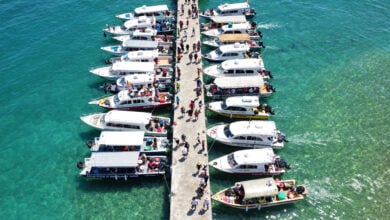Phu Quoc island pier with multiple speedboats loading tourists, aerial view, turquoise water