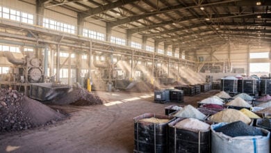 Rare earth oxide processing facility with refined mineral containers and industrial equipment