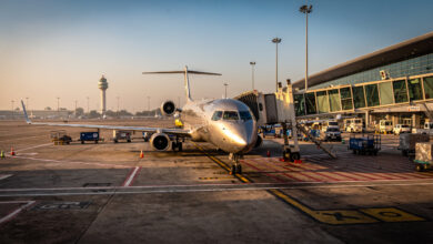 Regional jet aircraft on tarmac at Indian airport terminal, golden hour lighting