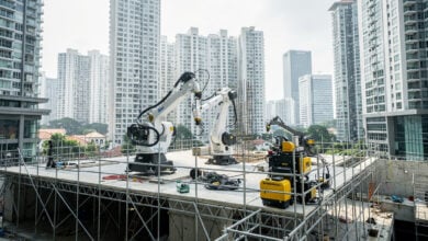 Robotic construction machinery on Singapore building site with urban skyline backdrop