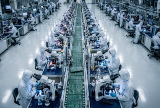 Semiconductor manufacturing floor with precision machinery and cleanroom workers, overhead view, Taiwan