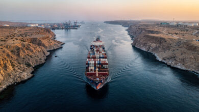 Tanker ship transiting narrow Strait of Hormuz waterway at dawn