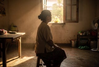Thai woman in home interior, soft natural light, contemplative expression