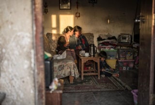 Young family in modest Thimphu apartment, warm interior lighting, domestic scene
