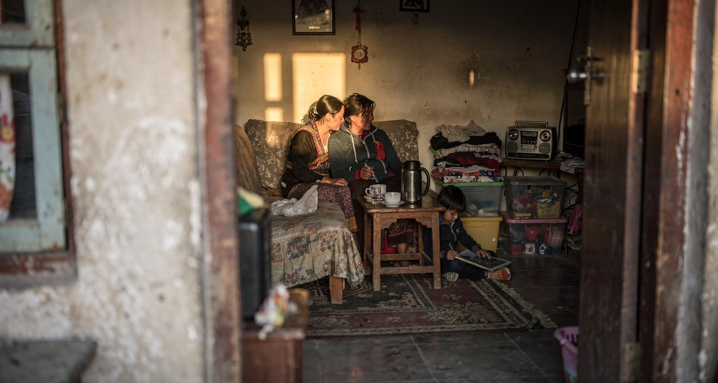 Young family in modest Thimphu apartment, warm interior lighting, domestic scene