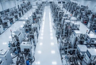 Advanced semiconductor fabrication facility interior with precision manufacturing equipment under blue-white lighting