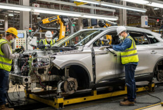 Assembly line workers installing components on Lincoln Nautilus in U.S. automotive plant