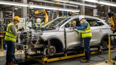 Assembly line workers installing components on Lincoln Nautilus in U.S. automotive plant