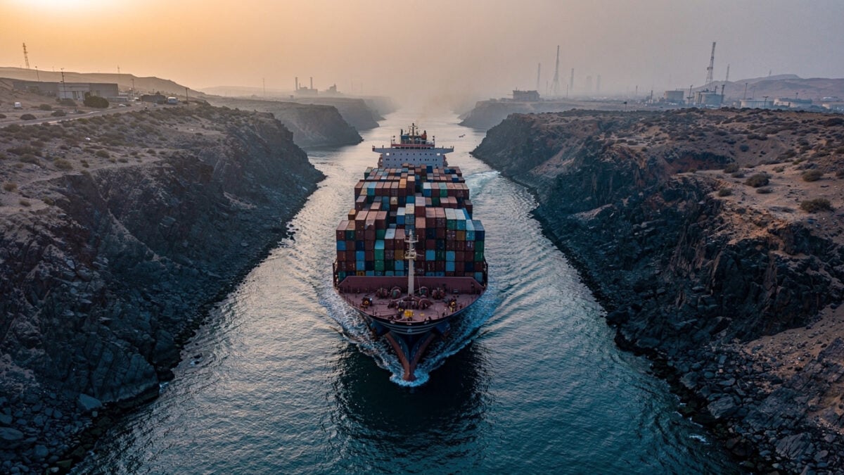 Container ship in narrow strait passage between rocky coastlines, Strait of Hormuz