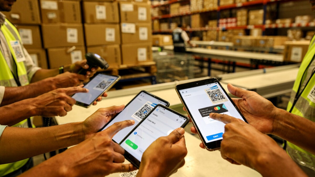 E-commerce fulfillment workers processing UPI payments on tablets in an Indian warehouse
