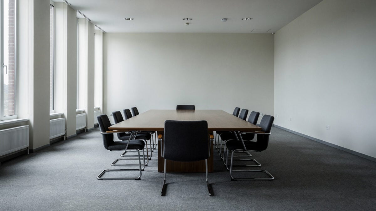 Empty conference table with eight chairs in formal institutional setting