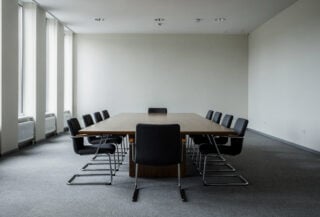 Empty conference table with eight chairs in formal institutional setting