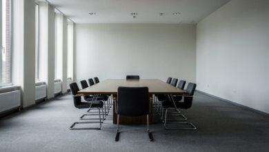 Empty conference table with eight chairs in formal institutional setting