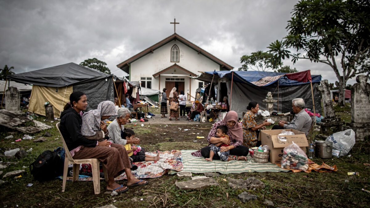 Families sheltering in churchyard on Flores after earthquake, tents and blankets visible