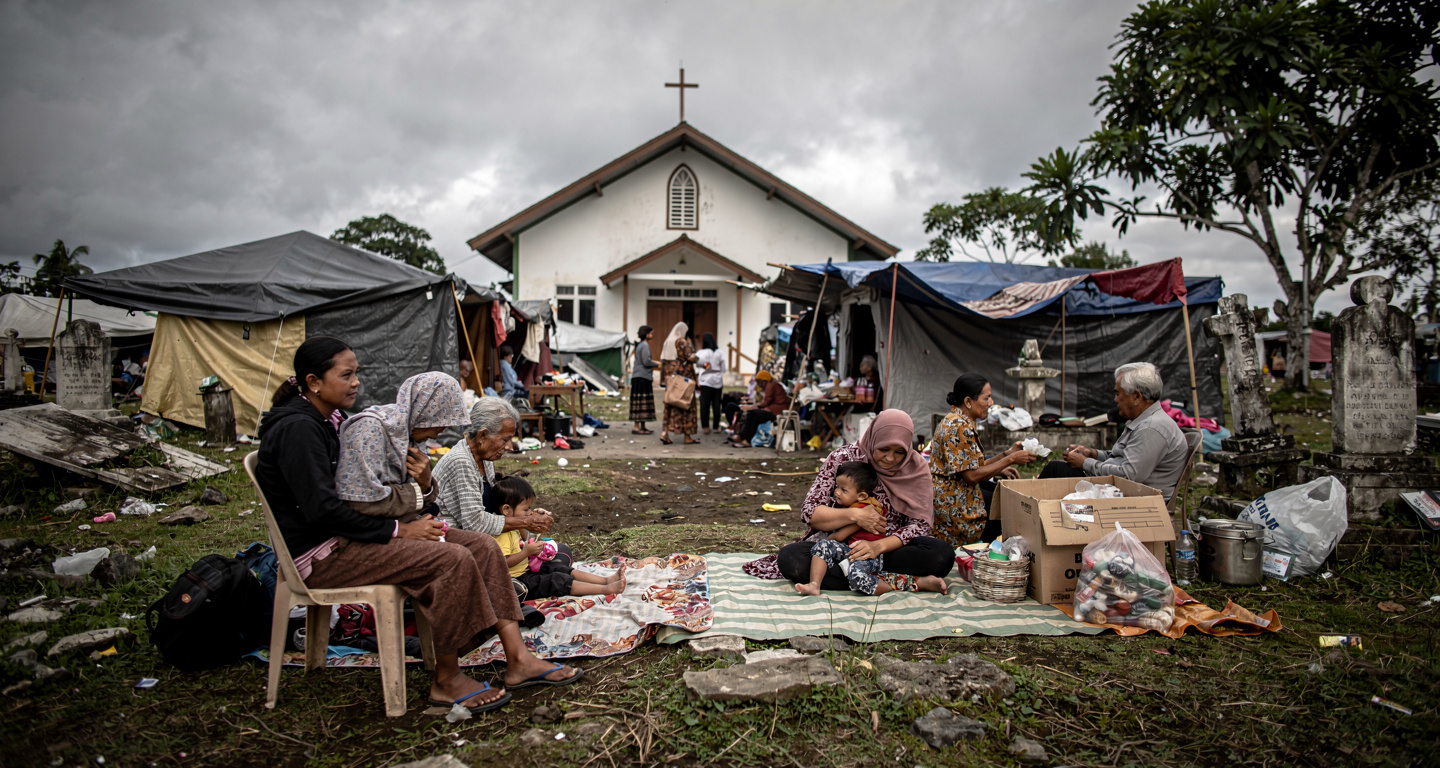 Families sheltering in churchyard on Flores after earthquake, tents and blankets visible