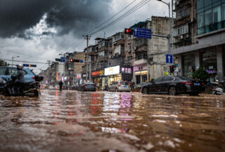 Flooded street in Shanghai during heavy rainfall, water rising against buildings