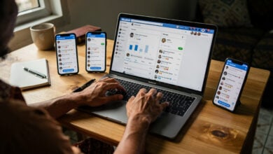 Indonesian content creator working at desk with multiple devices showing Facebook engagement metrics