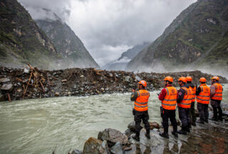 Rescue workers at debris-dammed barrier lake in Nepal-Tibet border Himalayan valley, monsoon conditions