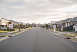 Suburban street with residential homes and for-sale signs, Brisbane, Australia