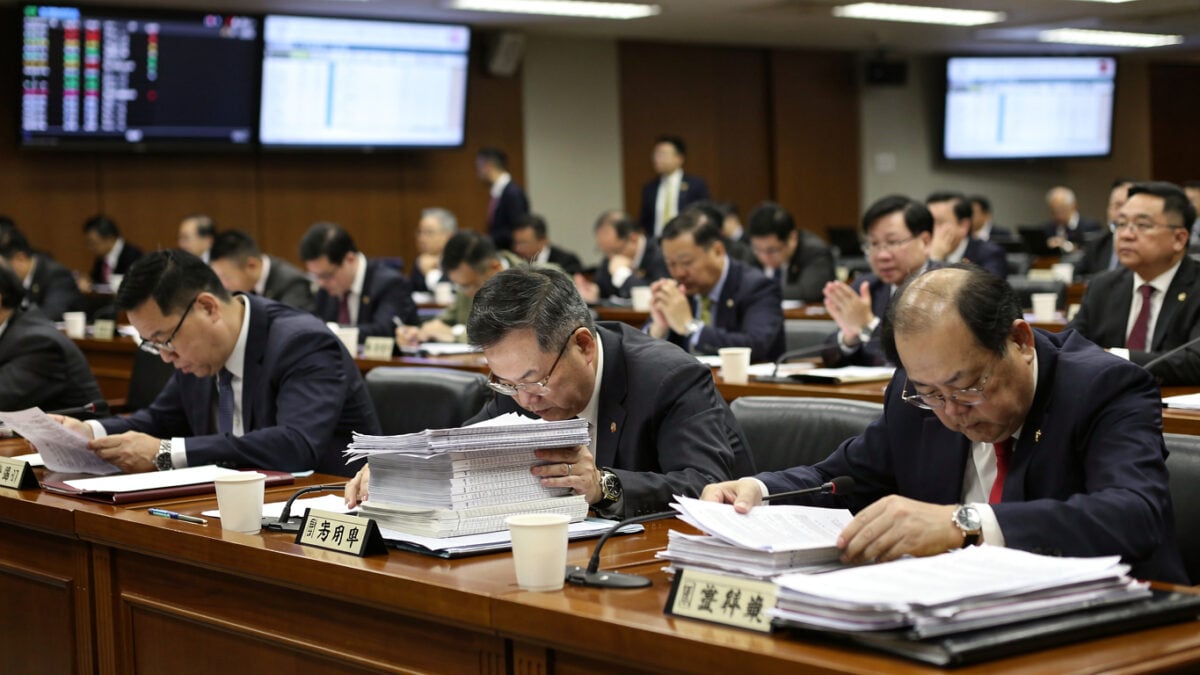 Taiwanese legislators in Legislative Yuan chamber reviewing budget documents during debate session