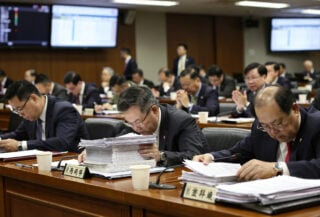 Taiwanese legislators in Legislative Yuan chamber reviewing budget documents during debate session