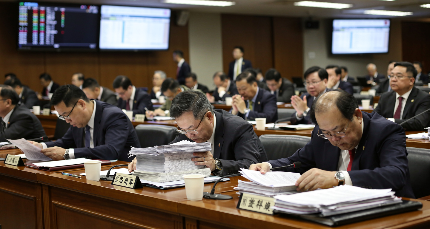 Taiwanese legislators in Legislative Yuan chamber reviewing budget documents during debate session