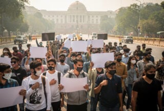 Young Indian protesters demonstrating in New Delhi street, diverse group, determined expressions
