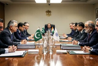Diplomats from India and Pakistan at a formal negotiation table, tension evident in their body language