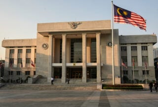 Kuala Lumpur Sessions Court building exterior, Malaysian flag, morning light