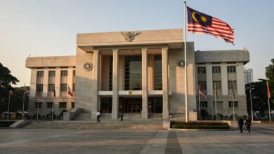 Kuala Lumpur Sessions Court building exterior, Malaysian flag, morning light