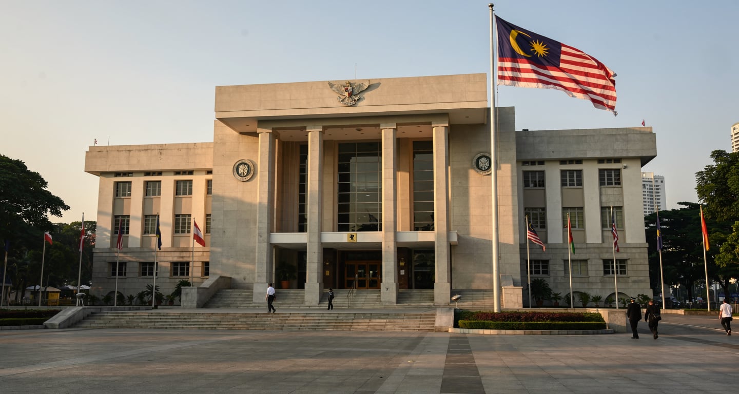 Kuala Lumpur Sessions Court building exterior, Malaysian flag, morning light