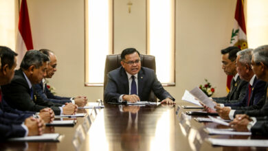 Malaysian cabinet officials at formal government table, one minister visibly tense, Kuala Lumpur