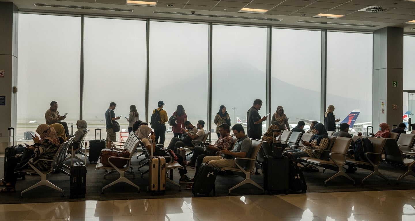 Passengers at Jakarta airport departure gates with ash-hazed windows during volcanic closure