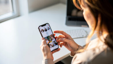 Person scrolling smartphone feed with hand near settings icon, office daylight
