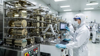 Semiconductor fab workers monitoring wafer production lines in Seoul fabrication plant under industrial lighting