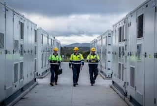 Technicians walking between battery units at NSW's Waratah site